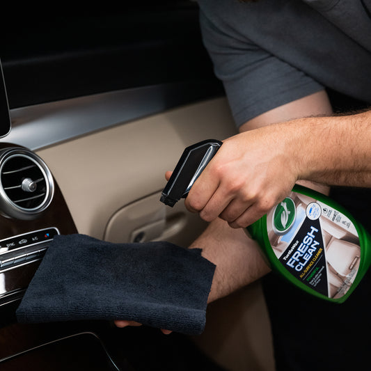 Man cleaning car interior with spray bottle. Features Turtle Wax Fresh Clean All Surface Cleaner.