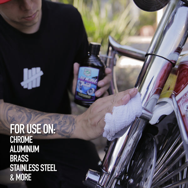 Man polishing chrome motorcycle parts with All Metal Polish. Auto detailing with car care supplies for a shiny finish.