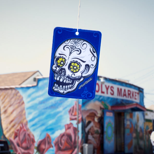 Blue paper freshener with a sugar skull art design hanging by string.