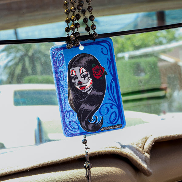 Car air freshener with a blue background and "La Catrina" image hanging with metal rosary.