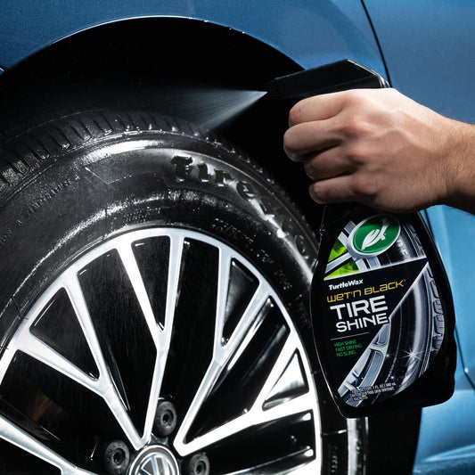 Applying Turtle Wax Wet'n Black Tire Shine to a vehicle tire. High shine, fast drying formula shown.