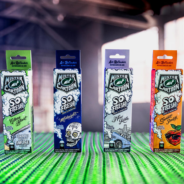 Four boxes of Mister Cartoon's So Fresh Odor Eliminating Auto Fogger are lined up, featuring Clean Blast, Midnight, New Ride, & Sunset Peach scents.