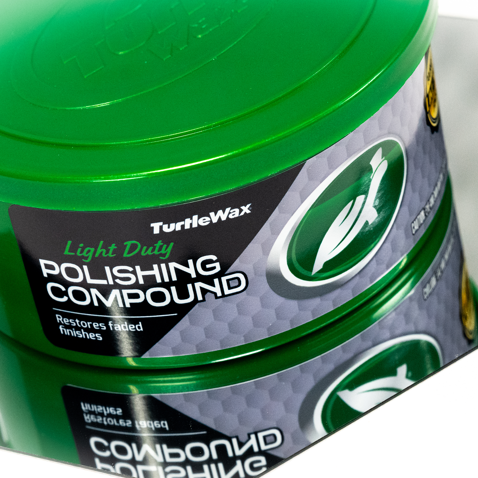Close-up: Turtle Wax Light Duty Polishing Compound in green container restores faded finishes.