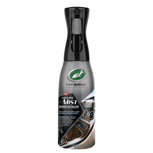 Bottle held mid-spray against dirty rim, showcasing spray pattern.