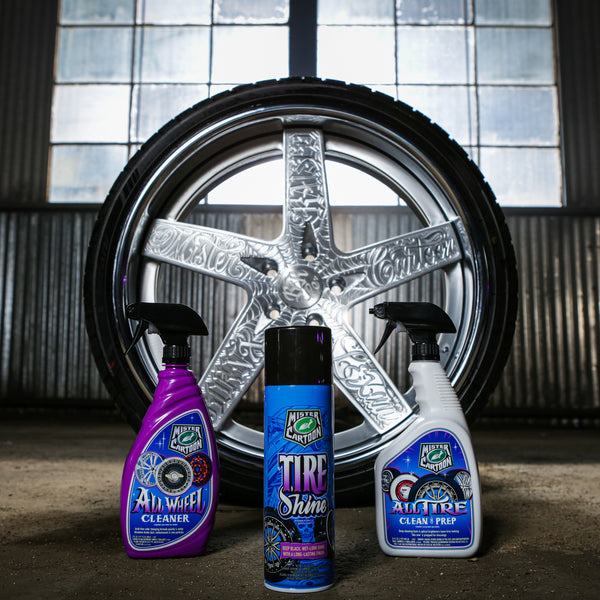 Low-angle view of air freshener hanging with out-of-focus wheels and suspension in the background.