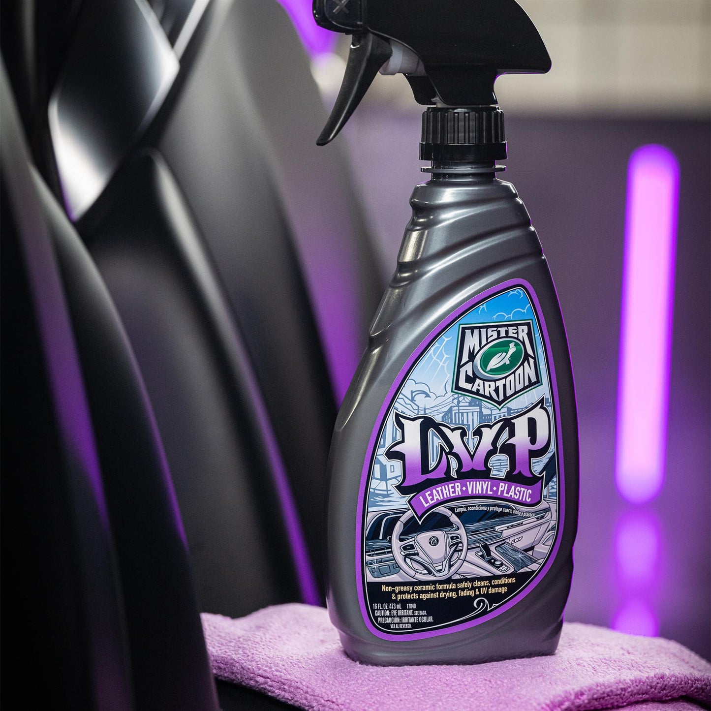 Mister Cartoon LVP Interior Cleaner & Protectant spray bottle shown against a car seat and purple lighting. Protects Leather, Vinyl, Plastic.