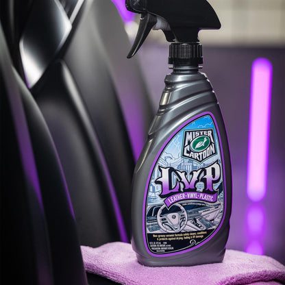 Mister Cartoon LVP Interior Cleaner & Protectant spray bottle shown against a car seat and purple lighting. Protects Leather, Vinyl, Plastic.