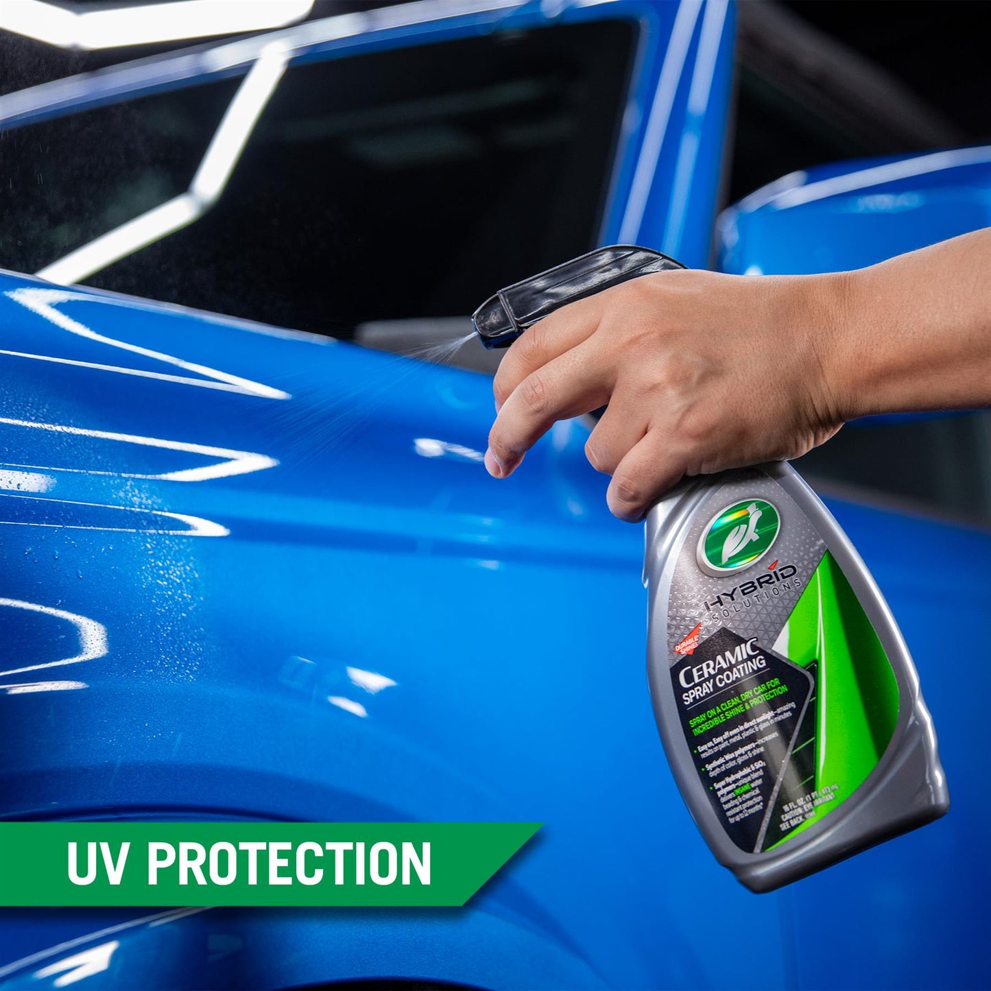Applying Turtle Wax ceramic spray coating to a blue car's exterior. Detailing product for shine and UV protection.