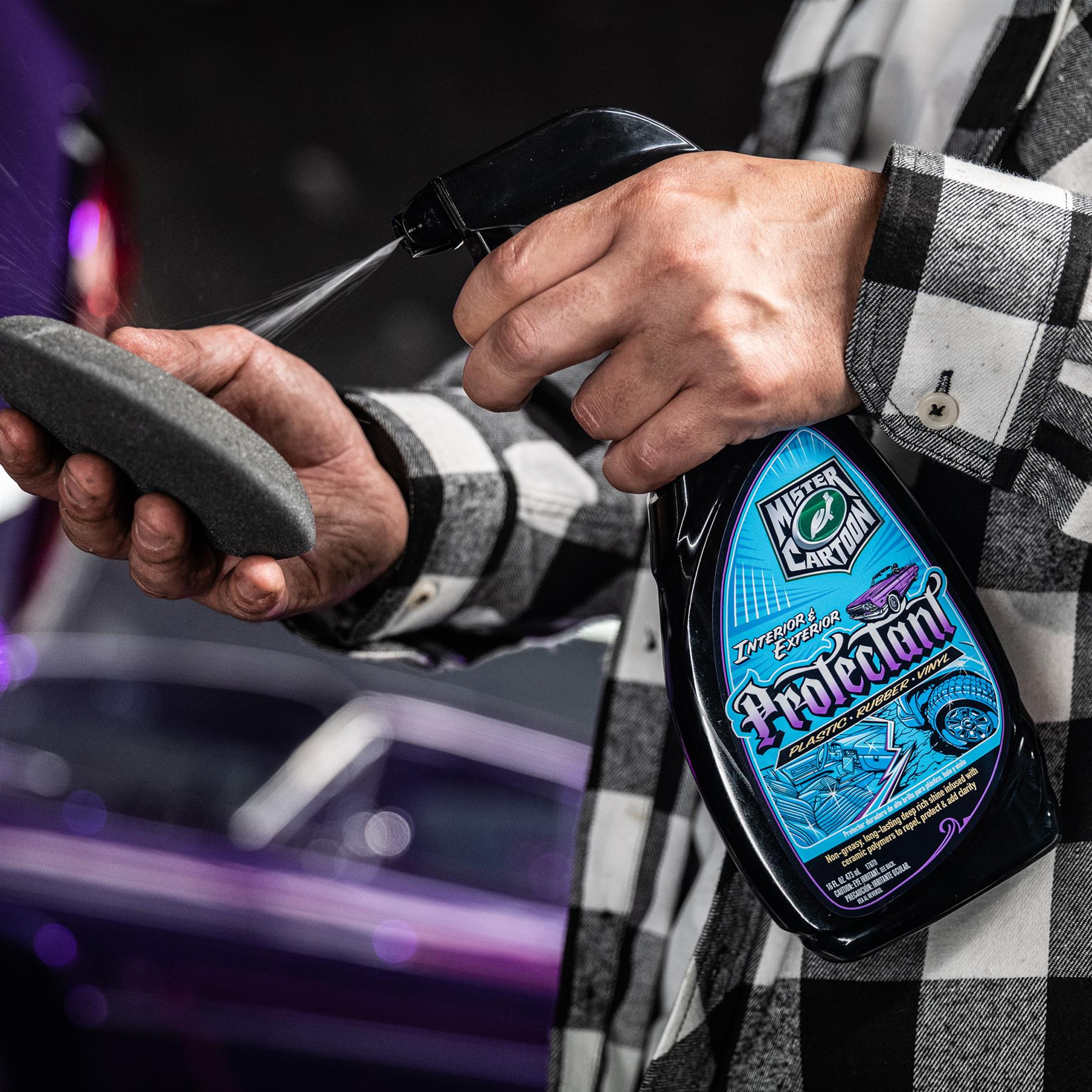 Man sprays Mister Cartoon Turtle Wax protectant on pad. Formula for auto interior & exterior: plastic, rubber, & vinyl. Ceramic polymers.