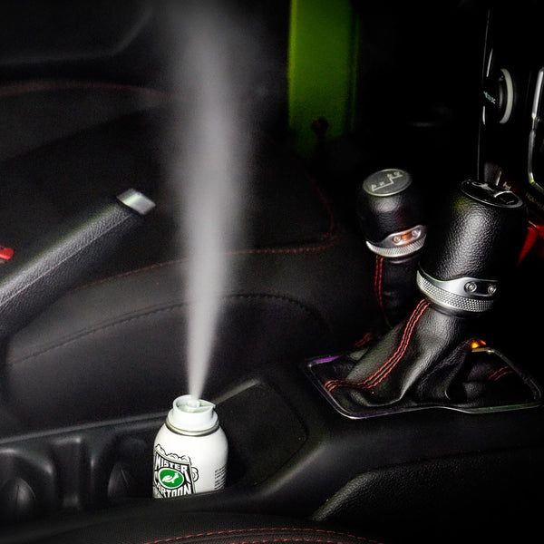 Angled lifestyle image showing a fogger product with mist lingering in a luxury car cabin.