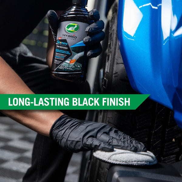 A hand using an applicator pad to apply trim restorer to the black trim of a car, showcasing the long lasting black finish of the product. 
