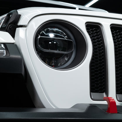 Close-up of a white SUV. The grill and headlight are visible. Car care and detailing may be needed.