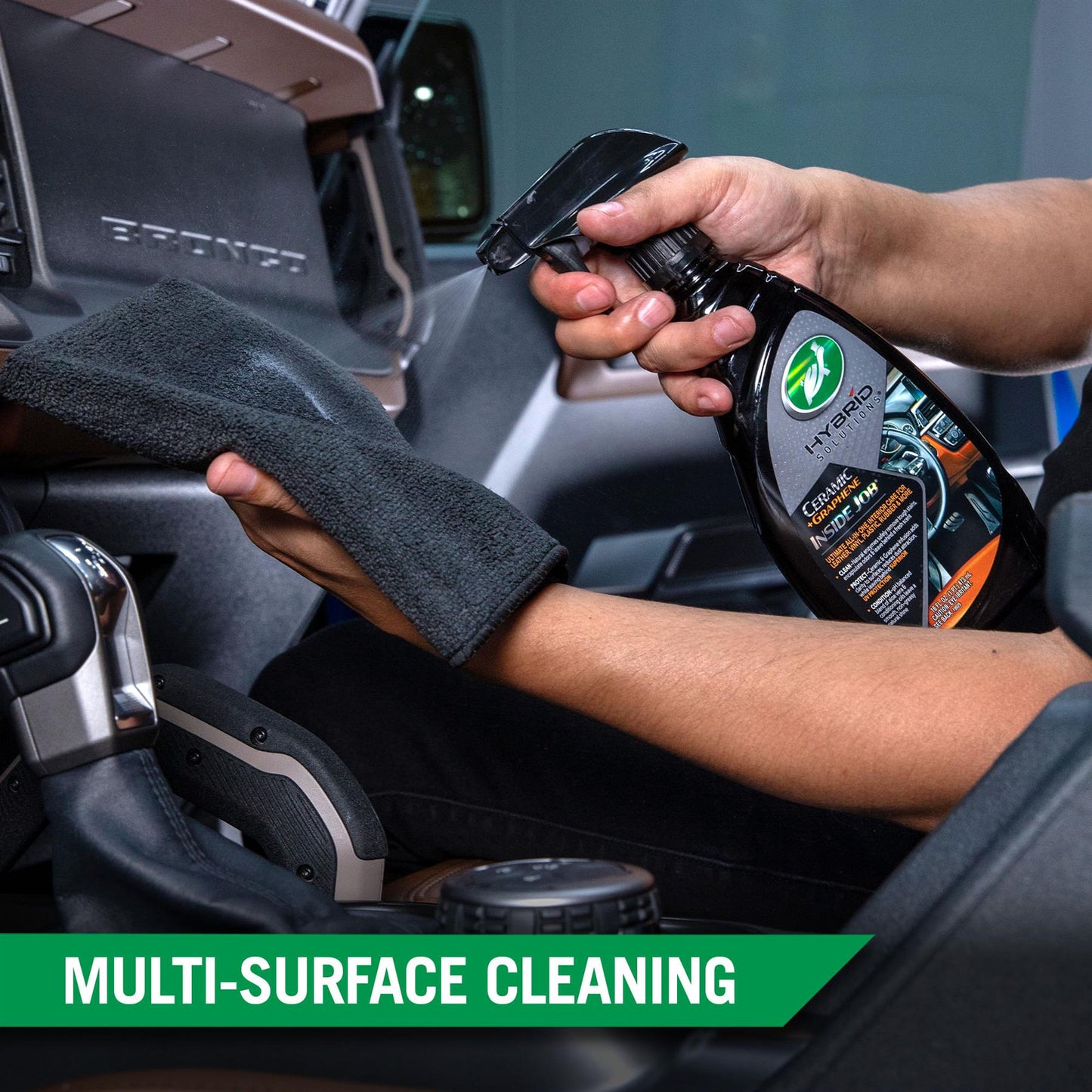 Detailing a car interior with Turtle Wax's hybrid solution. The man is applying cleaning product with a microfiber cloth to dashboard.