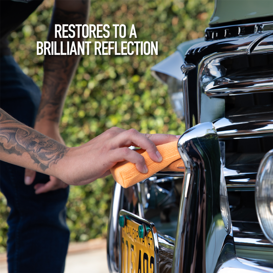 Detailing chrome car bumper. An auto enthusiast with a cloth polishes the chrome of a vintage automobile.