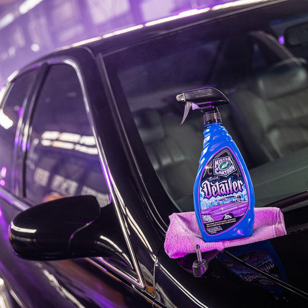Product shot of Quick Detailer bottle sitting on a car hood with clear coat reflections.
