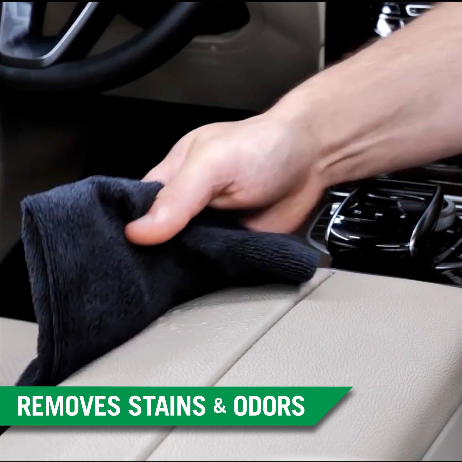Detailing a car's interior: A hand wipes a beige leather surface with a dark cloth. Car care and cleaning.