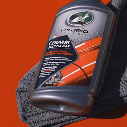 Turtle Wax Hybrid Solutions ceramic polish and wax for auto paint correction. The bottle rests on a gray detailing cloth.