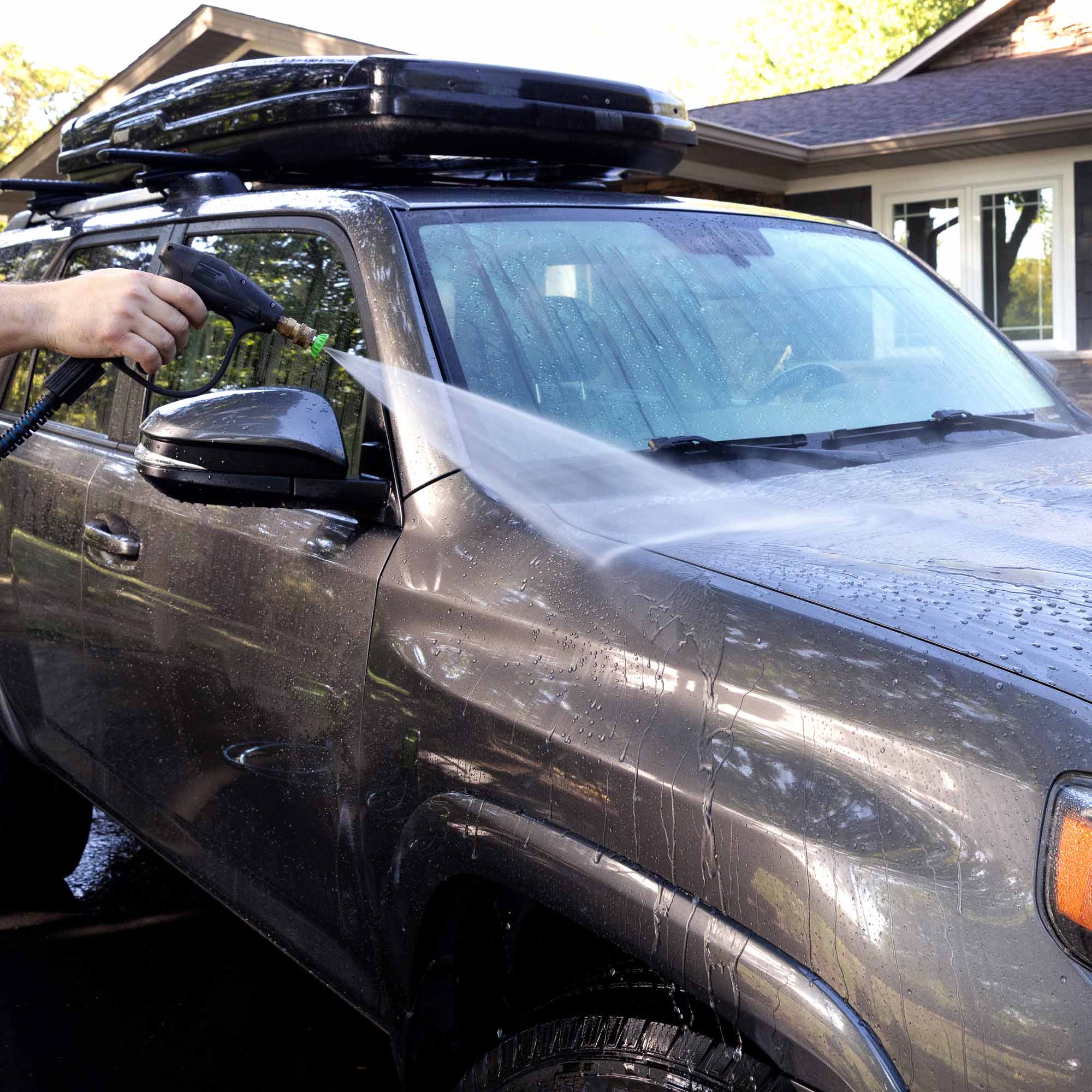 Man rinsing a car after using the turtle wax wax and dry plus 