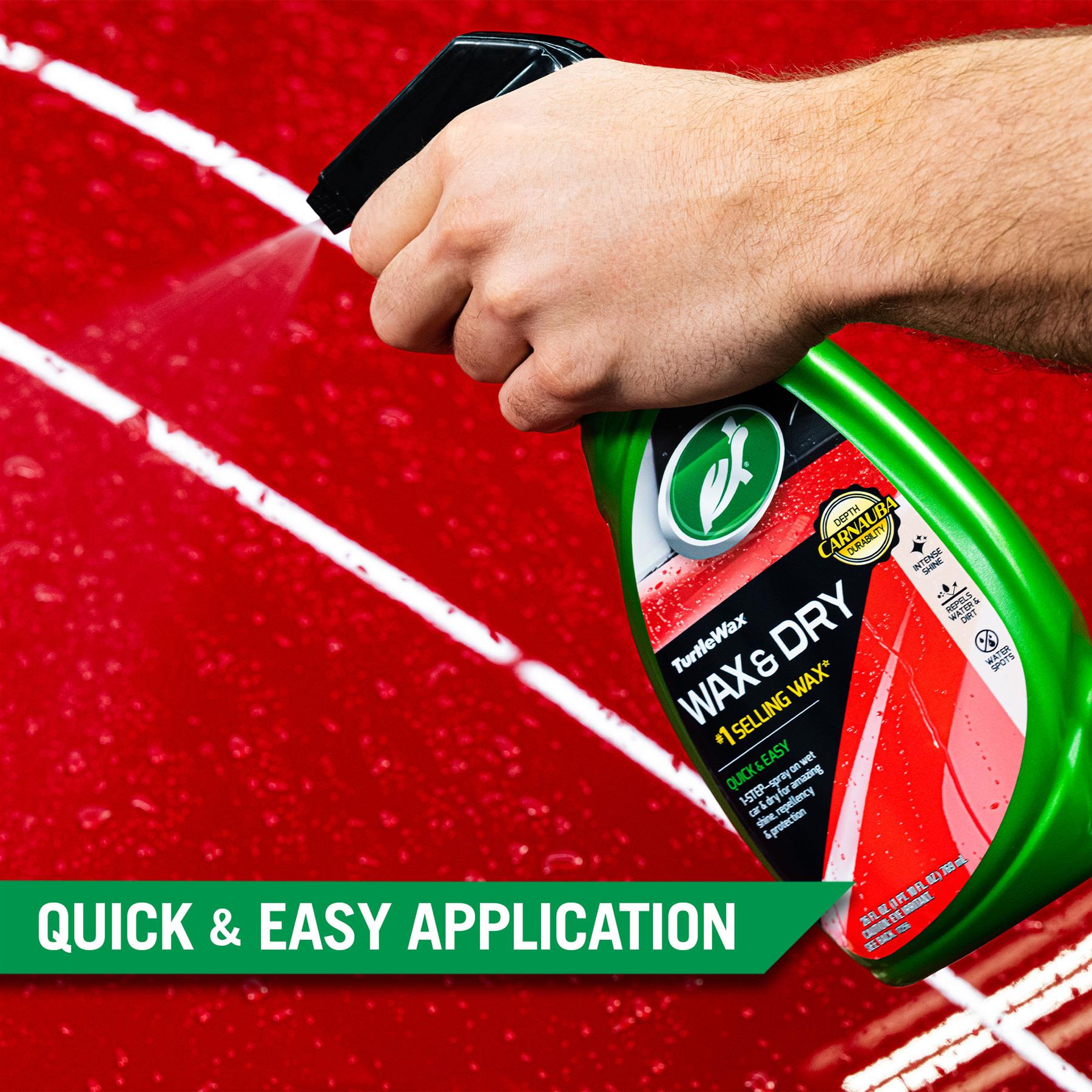 Person sprays Turtle Wax Wax & Dry onto a red car surface. This exterior detailer offers quick car cleaning and protection.