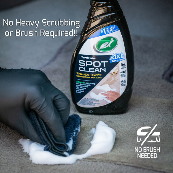 A hand uses a microfiber uses a black microfiber towel to clean the carpet. Text overlay reads "No heavy scrubbing or brush required!"